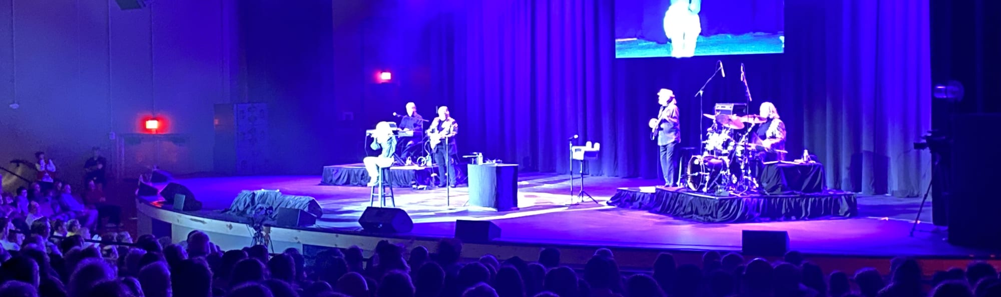 signer on stage in chair washed out by the lights Indianapolis